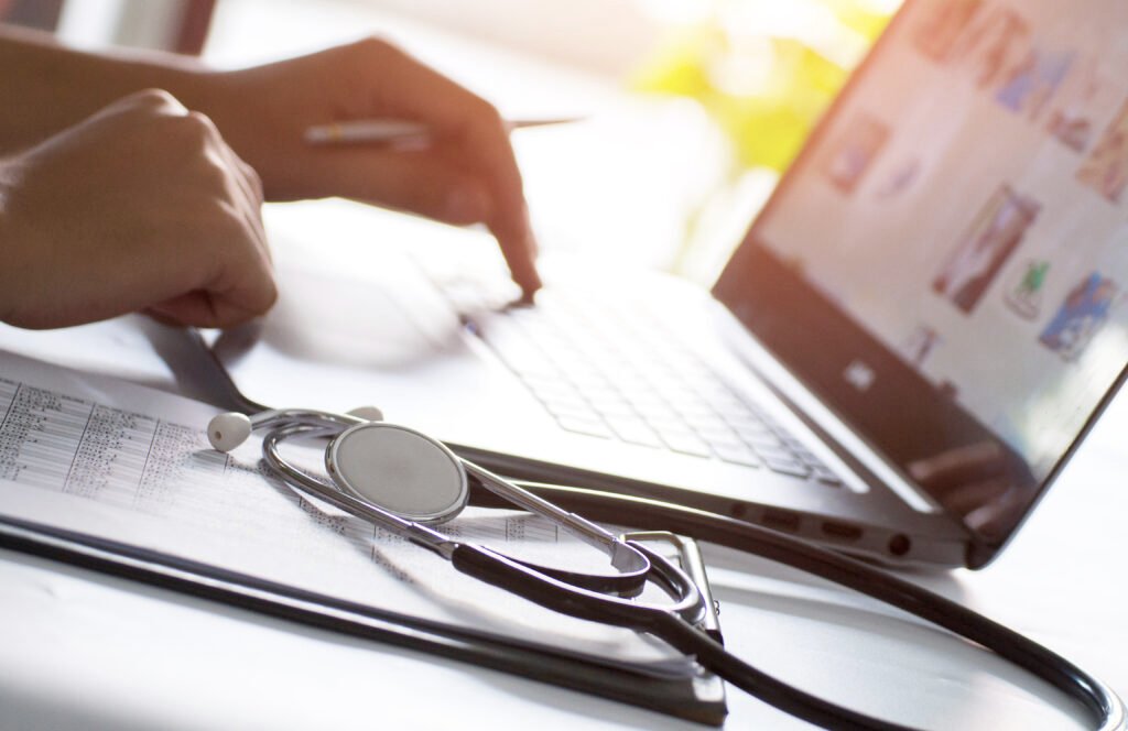 a telehealth nurse working on a laptop