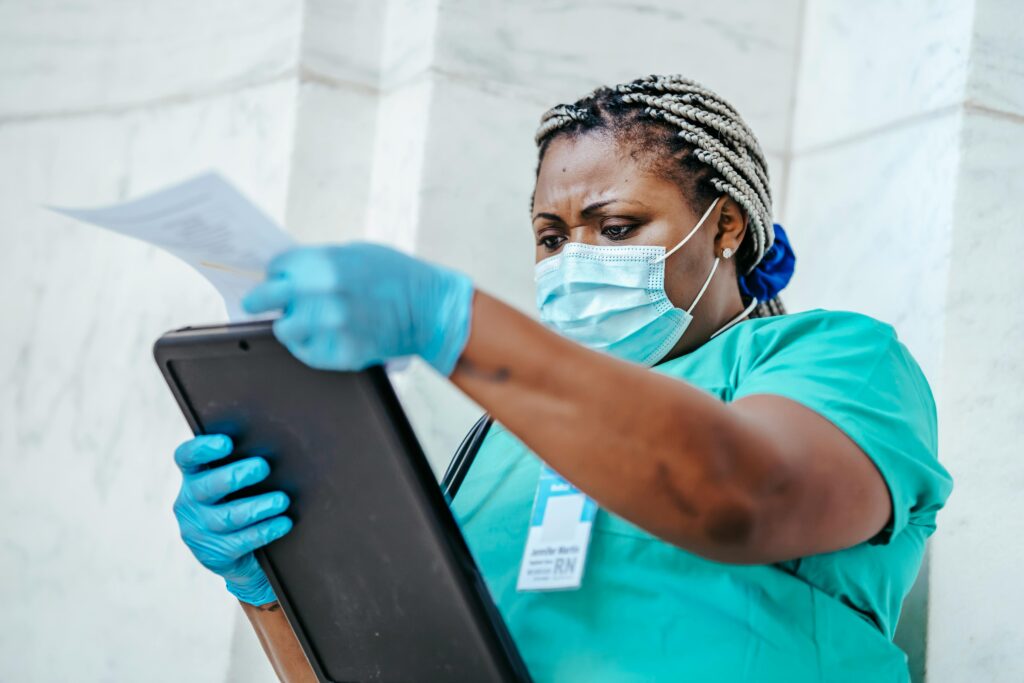 a nurse wearing a mask looking at her schedule